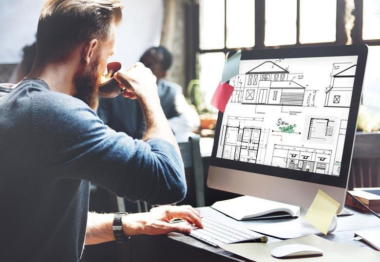 Pessoa analisando o desenho de uma edificação na tela do computador